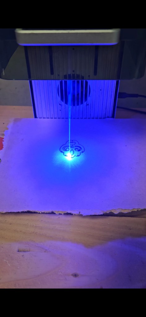 Découpe au laser d’une forme de boucle d’oreille dans du bois recyclé